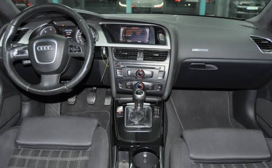 Interior del coche con el volante y el equipo de música de serie antes de la instalación